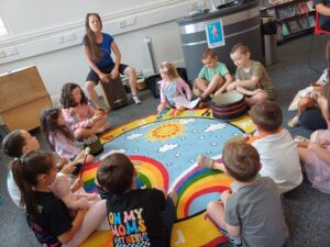 Children sat in a circle listening to a librarian