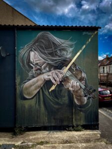 Street mural depicting man playing violin