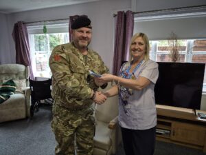 Army Cadet presents care home manager with donation